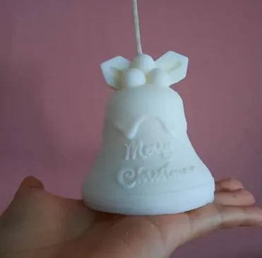 Vela blanca con forma de campana con la frase Merry Christmas