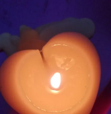 Vela con forma de corazón encendida
